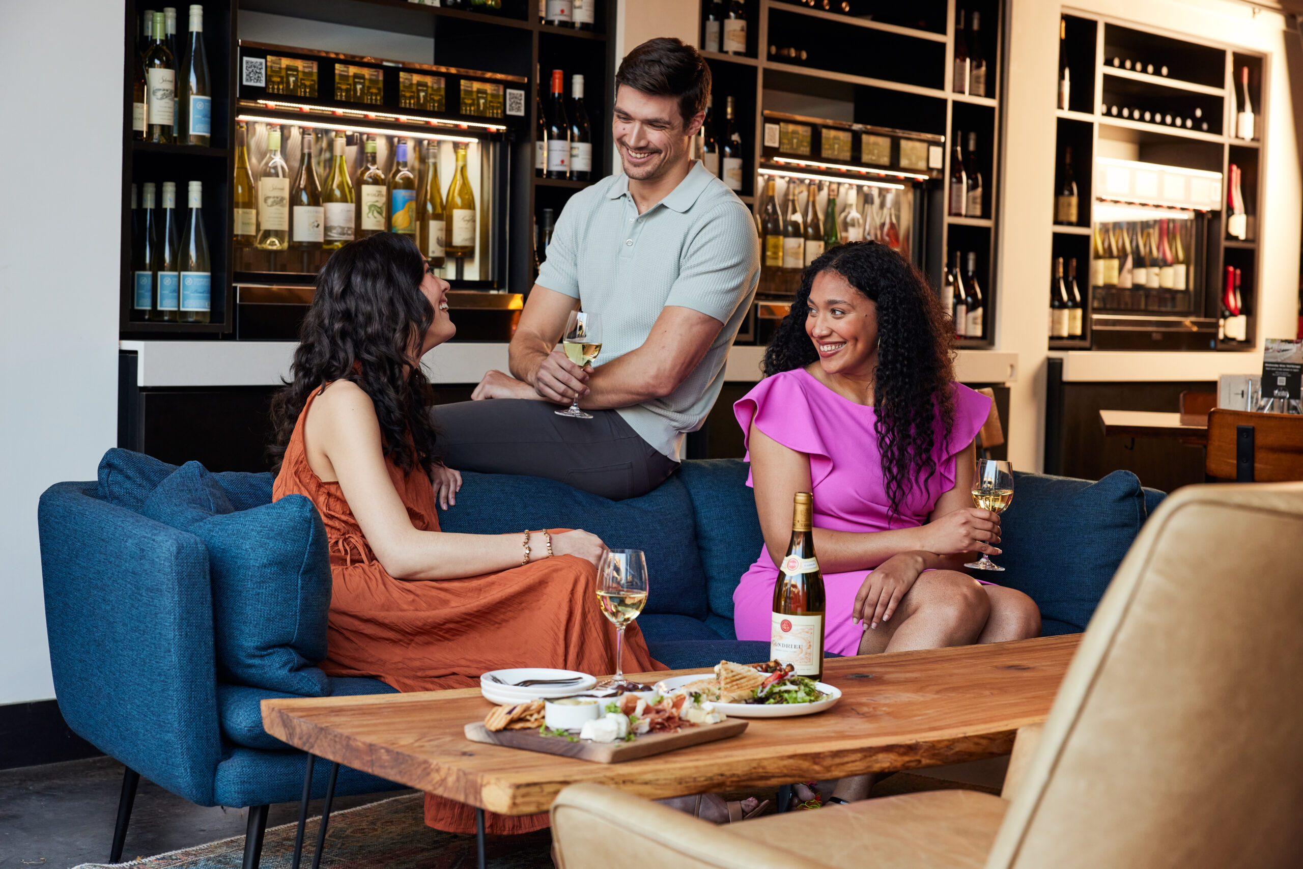 group sitting on couch drinking wine